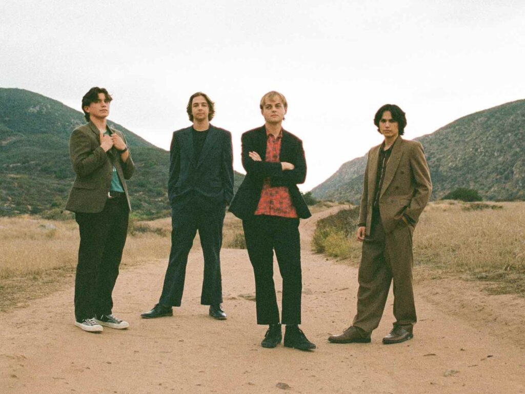 The band Blair Gun press image on a dirt road with hills in the background